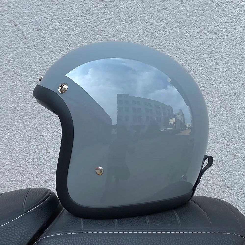 Retro-style open-face motorcycle helmet in glass fibre construction shown in a cement grey colour.
