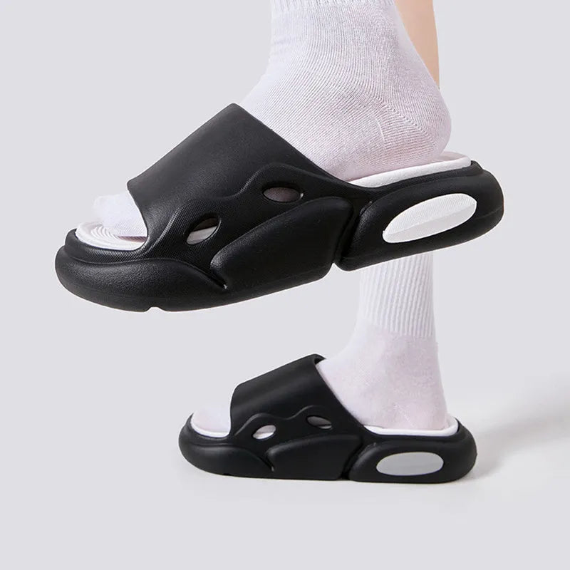 Two-colour couple slippers showing thick EVA sole and round toe, displayed in black and white colourway.