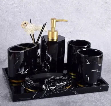 Four-piece ceramic bathroom set with bright glaze finish including bottle, cup, toothbrush holder, and soap dish