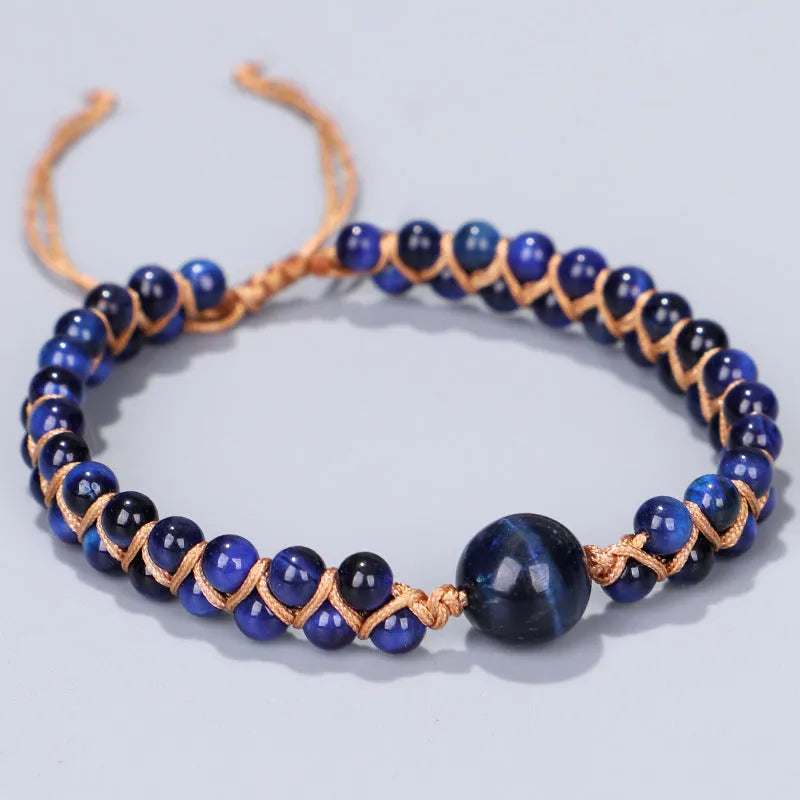 Handmade woven geometric pull bracelet with blue Tigereye stone beads on a wrist.