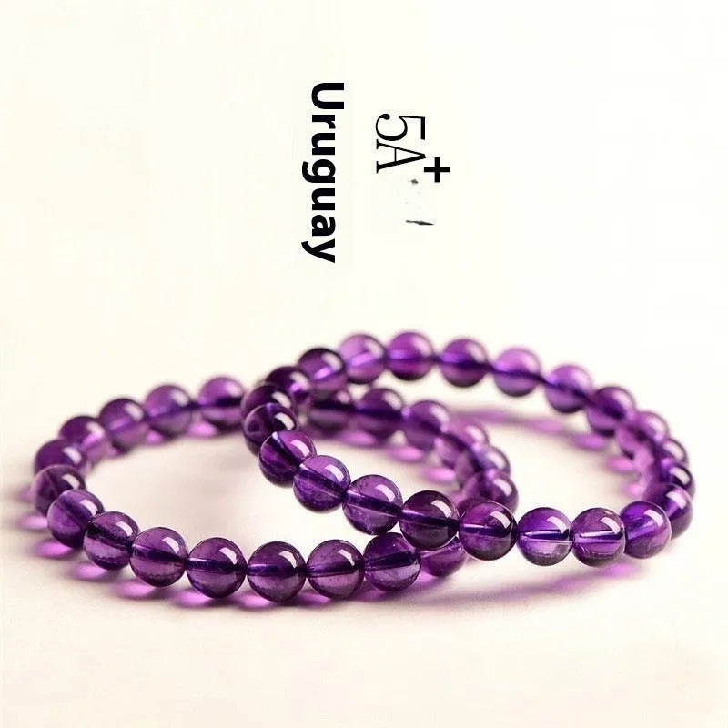 Natural Uruguayan amethyst scattered beads bracelet in various grades and sizes on a white background.