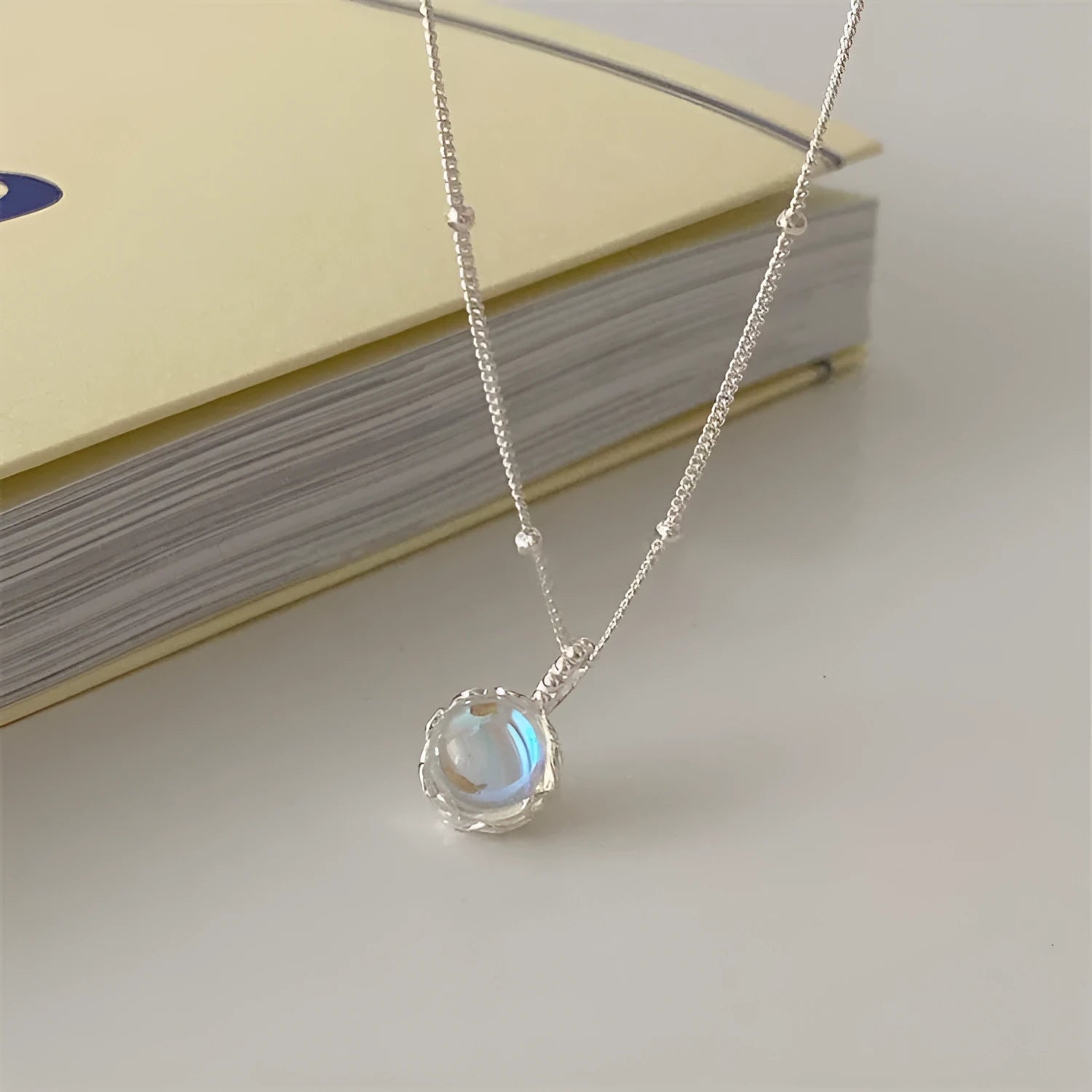 Silver geometric pendant on a curb chain necklace, adjustable from 41cm to 50cm length.