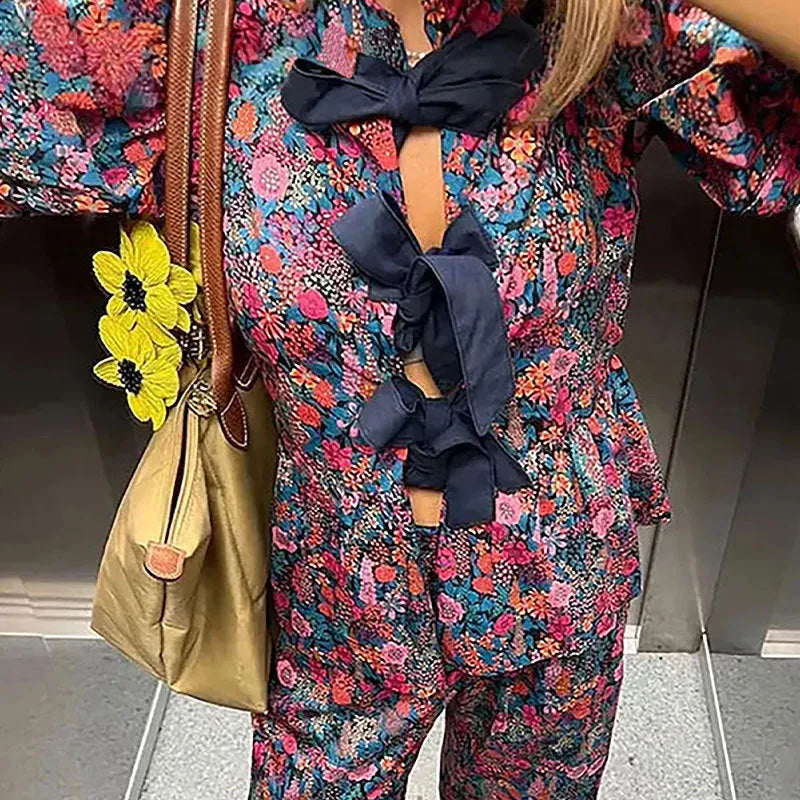 Women's floral printed trousers suit with tie-neck top featuring puff sleeves and matching trousers