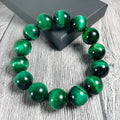 Green tiger eye stone bracelet with geometric polished beads showing banded natural patterns