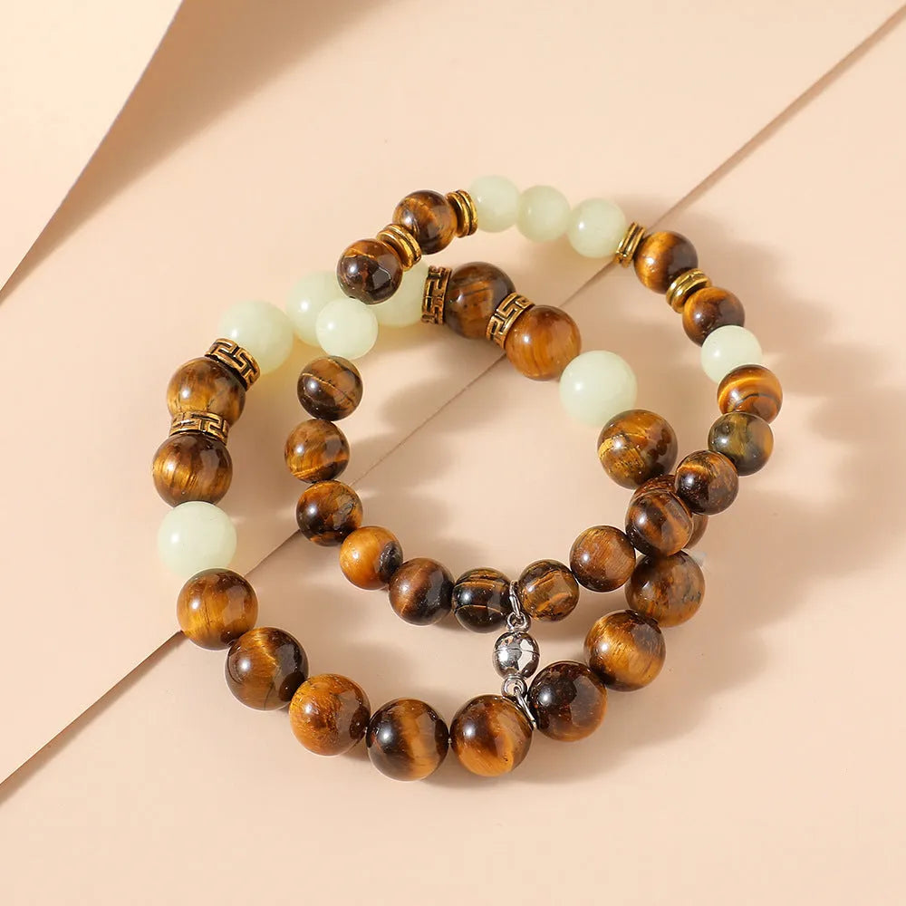 Amber Y552 luminous geometric couple bracelet on dark background showing glow effect