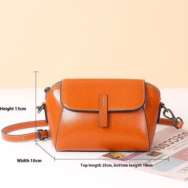 Women's brown shell-shaped messenger bag in oil wax leather with cross-body strap and organised interior