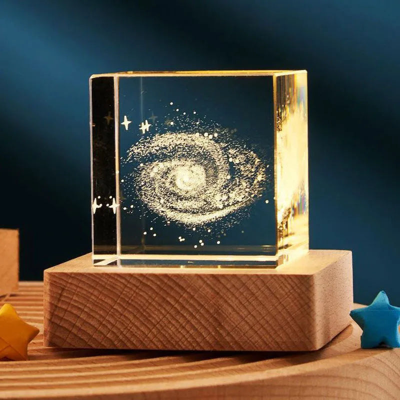3D transparent crystal cube night lamp with warm light pattern on wooden desktop