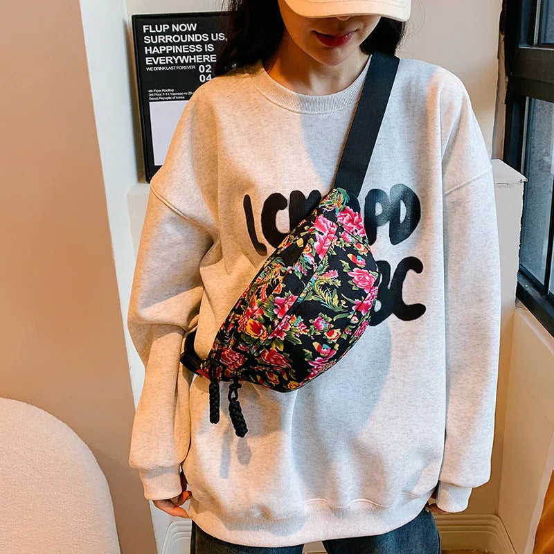 Women's nylon waist bag with big floral pattern, contrast stitching, and three-dimensional outer pocket in black