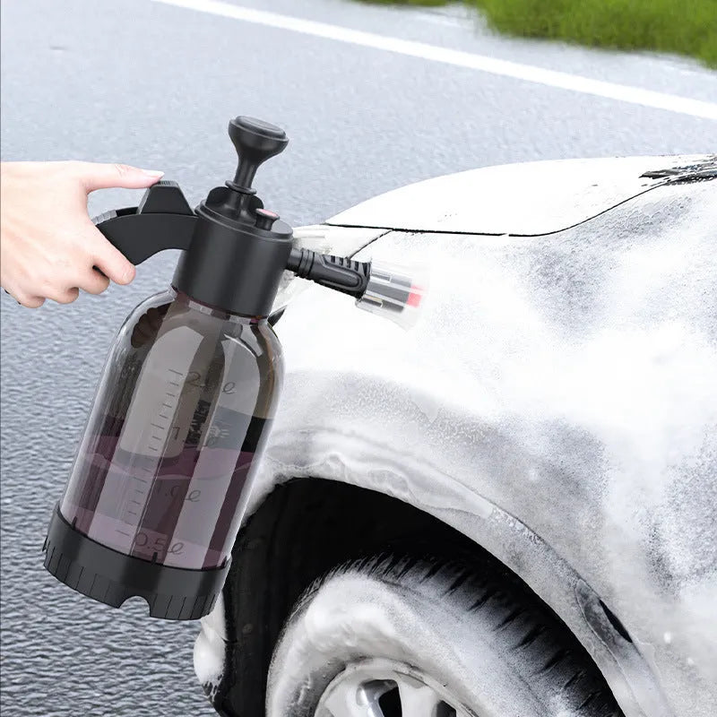 Black 2L foam watering can sprayer with handle and two nozzle attachments on a white background