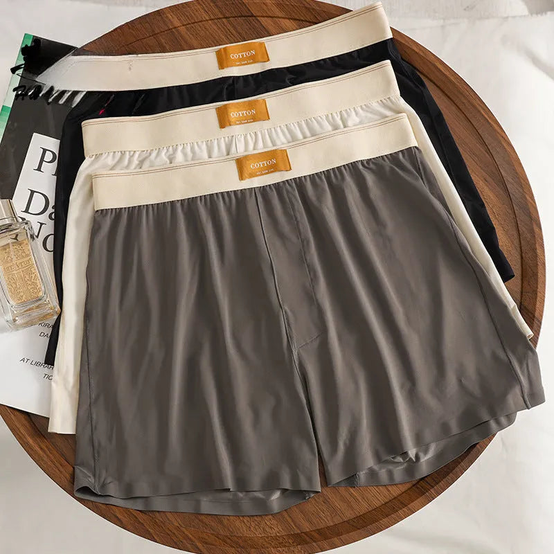Pack of three men's solid colour loose fit ice silk boxer shorts on a mid waist.