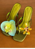 Handmade women's high heel semi-slipper sandals with asymmetric flower detail, calf leather upper, square toe, and EVA sole in black, green, pink, and white