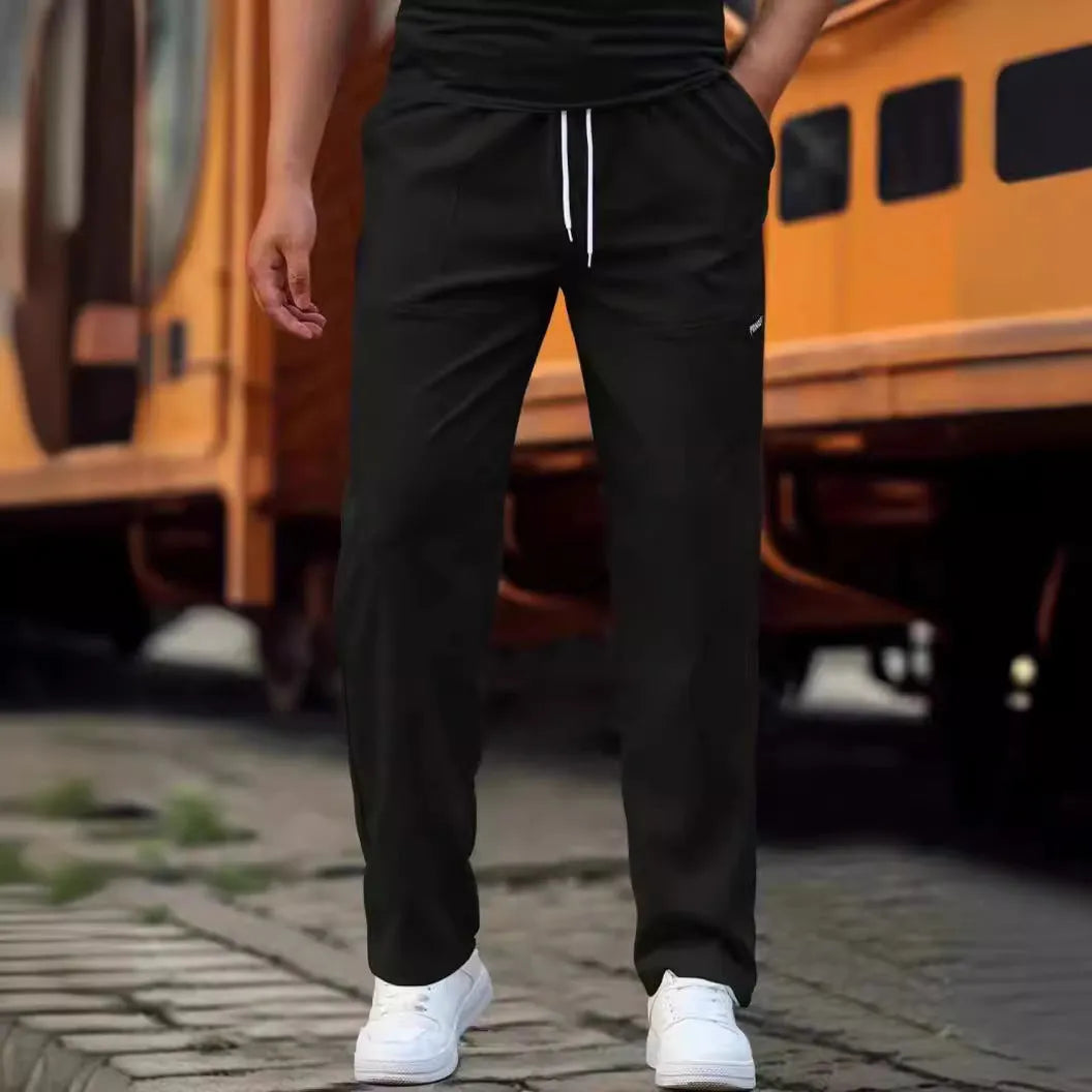Men's polyester trousers in light grey, shown folded, for casual spring and autumn wear.