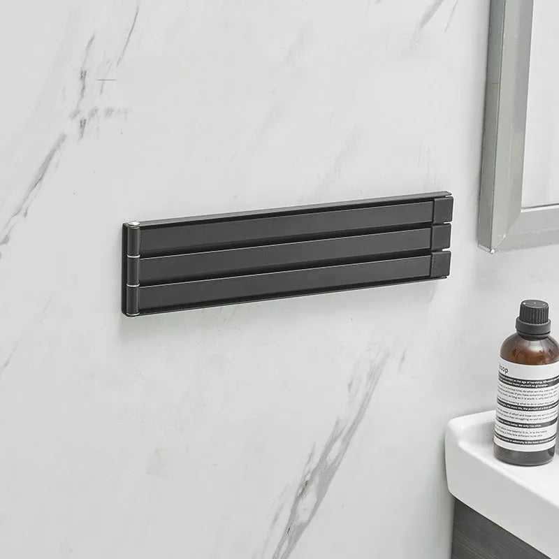 Black folding non-perforated towel bar on tiled bathroom wall, nail-free adhesive installation
