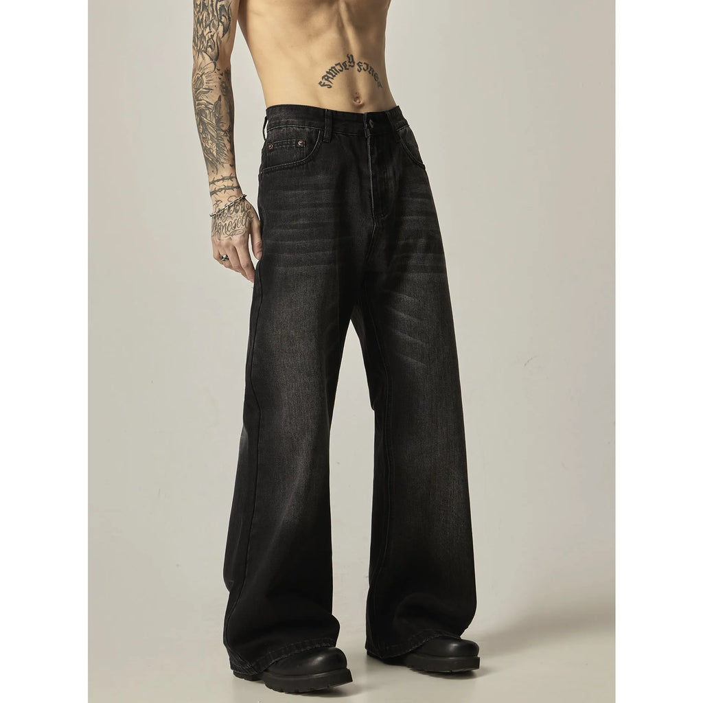 Man's black loose-fit straight-leg jeans with a retro style on a plain background.