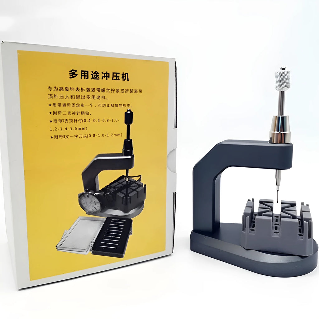 Silver multi-purpose press strap removal tool made from tool steel on a work surface.