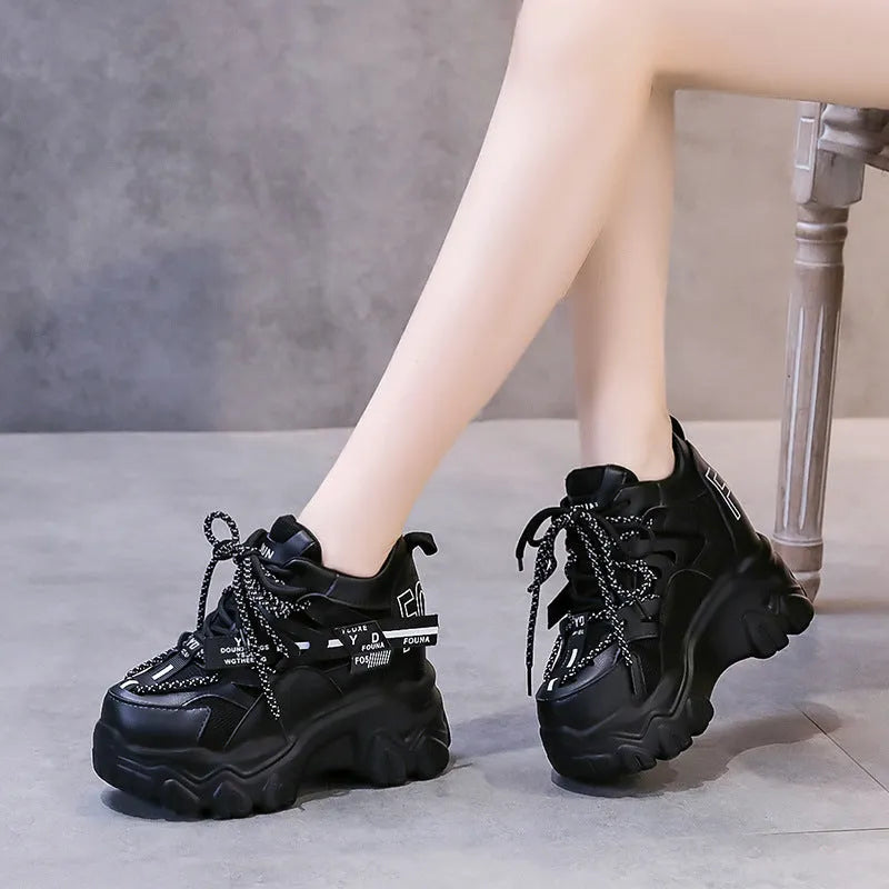 Women's white mesh platform trainers with cross strap and rubber sole showing side profile