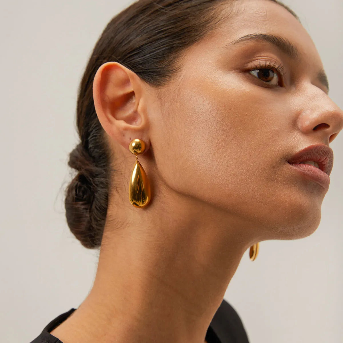 Gold electroplated stainless steel water drop pendant earrings with a geometric hemisphere design.