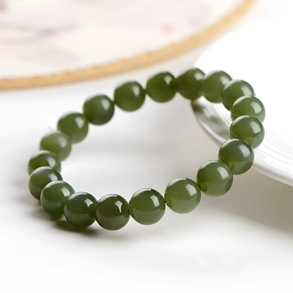 Polished Hetian jade bead bracelet in ice-clear colours on a wrist, showing spherical beads.