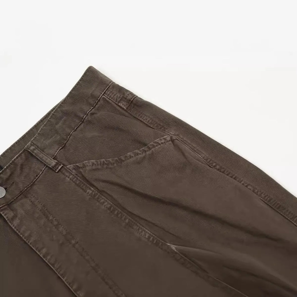 Men's brown straight-leg cotton trousers showing high-waist design with wide leg opening and zipper fly