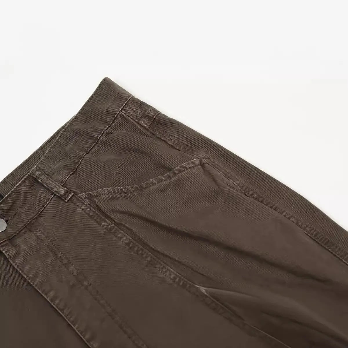 Men's brown straight-leg cotton trousers showing high-waist design with wide leg opening and zipper fly