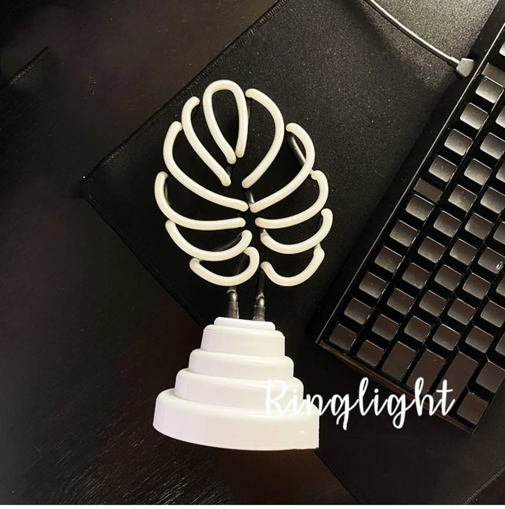 White tube bamboo shape desktop lamp emitting green light, with USB cable.