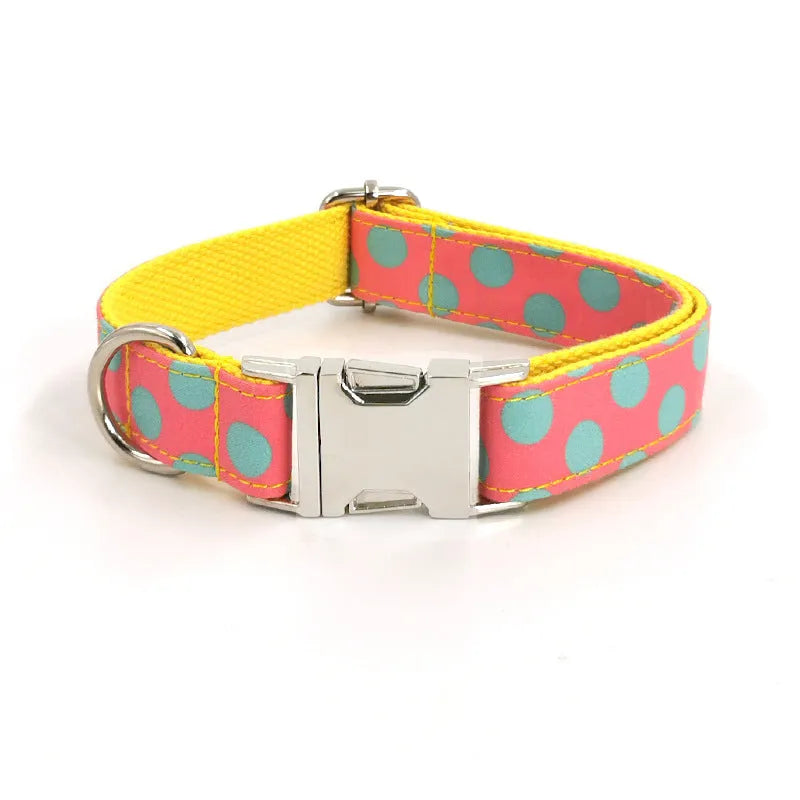 Yellow polka dot pet collar and matching hand-held traction rope lead set on plain background