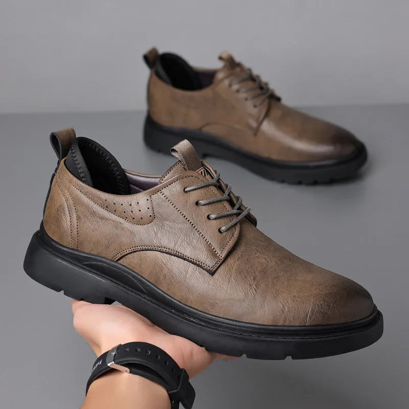 Men's black and brown leather shoes with rubber sole and sewn detailing on a white background.