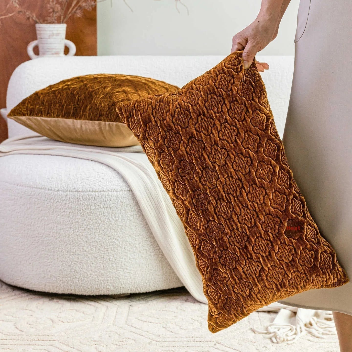 Brown gold antique-style quilted square cushion pillow with three-dimensional texture on a chair.