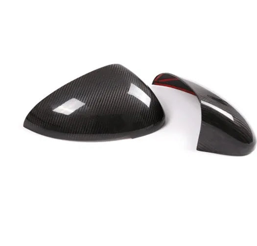 Pair of black true carbon fibre rearview mirror covers for Porsche Macan on a white background.