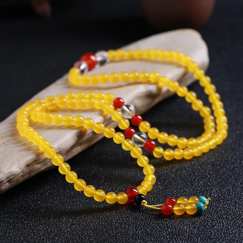 108-bead polished agate and crystal necklace with geometric beads and matching canary stone bracelet on display