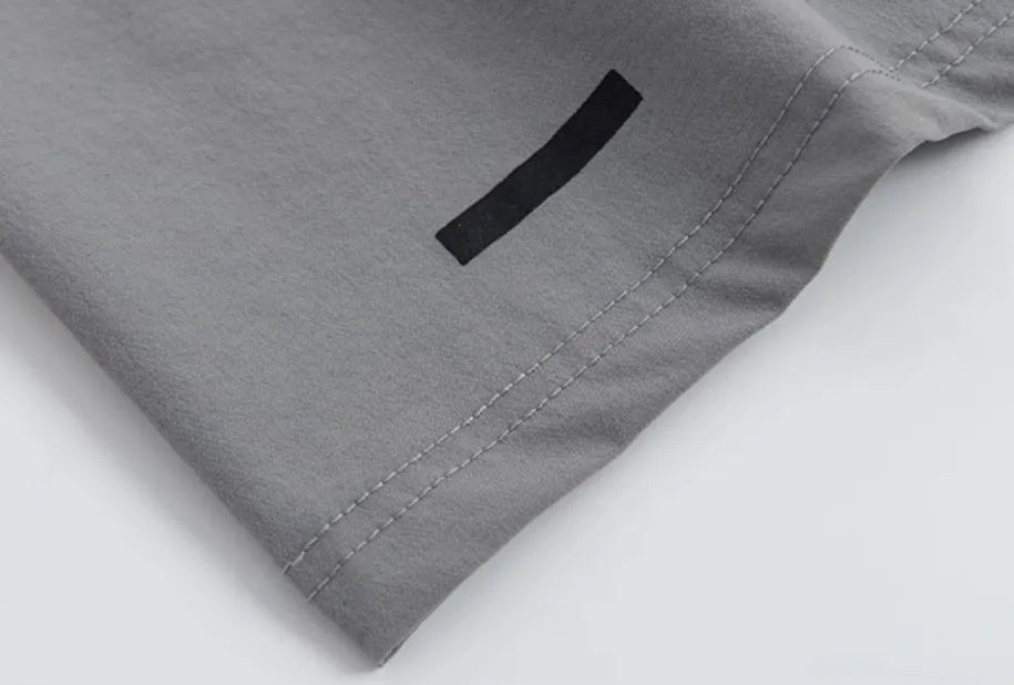 Loose cropped sports pants with printed waistband in grey, black, and blue colour options