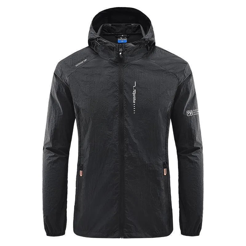 Man wearing a lightweight grey hooded nylon summer jacket outdoors.