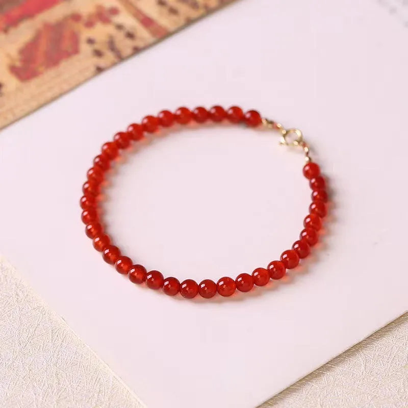Ultra-thin red agate small bracelet for women, classic style, on a plain background.