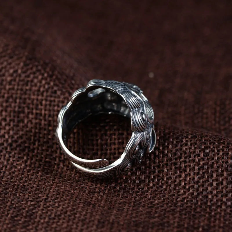 Silver open-style ring with detailed domineering jibeast animal pattern and diamond accents