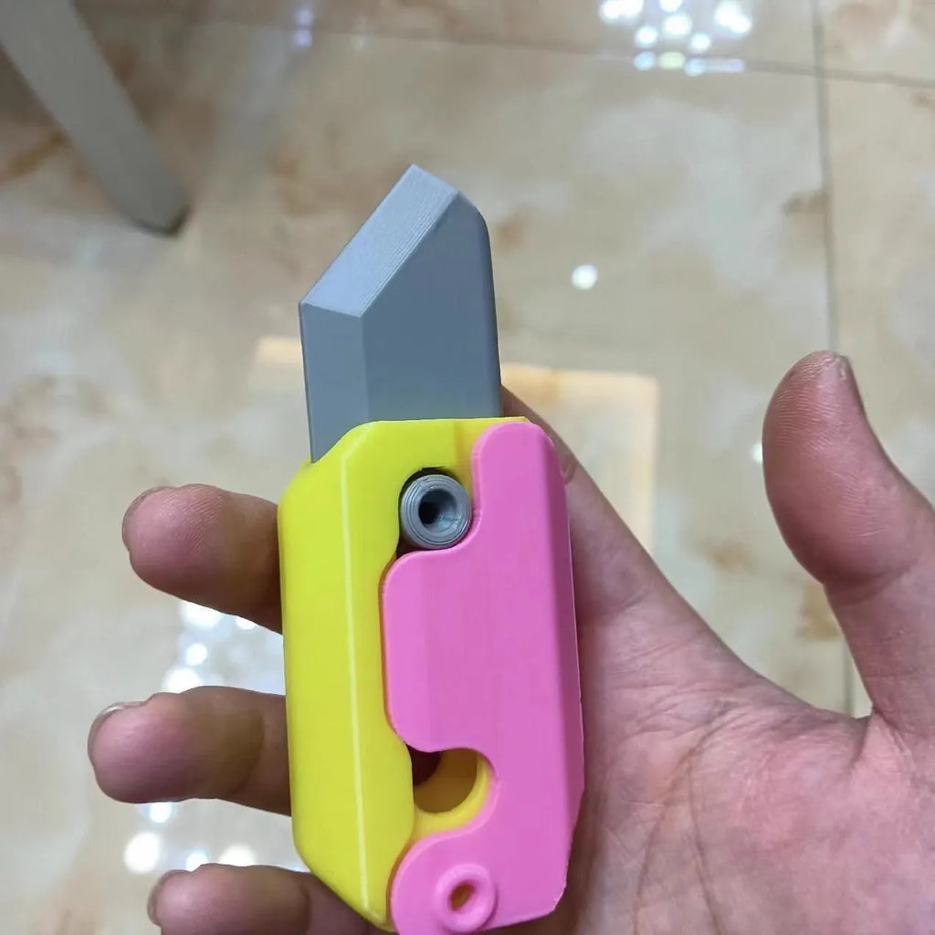 3D printed gravity carrot fidget knife in orange, purple and green colour on white background