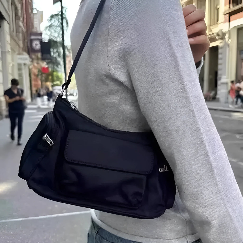 Black women's shoulder bag with double pockets and crossbody strap showing side line detailing