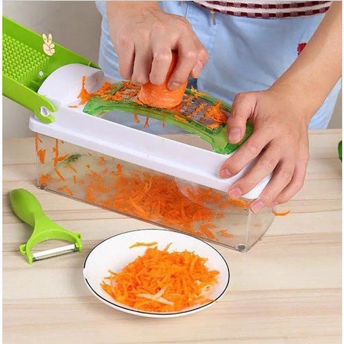 Green multifunctional vegetable chopper with handle, grater, and stainless steel blades on a chopping board
