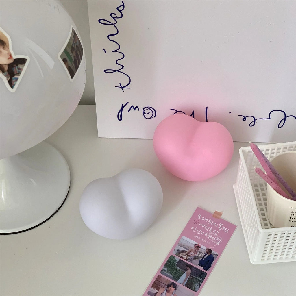 White or pink vinyl love heart atmosphere lamp in small or large size on a table.