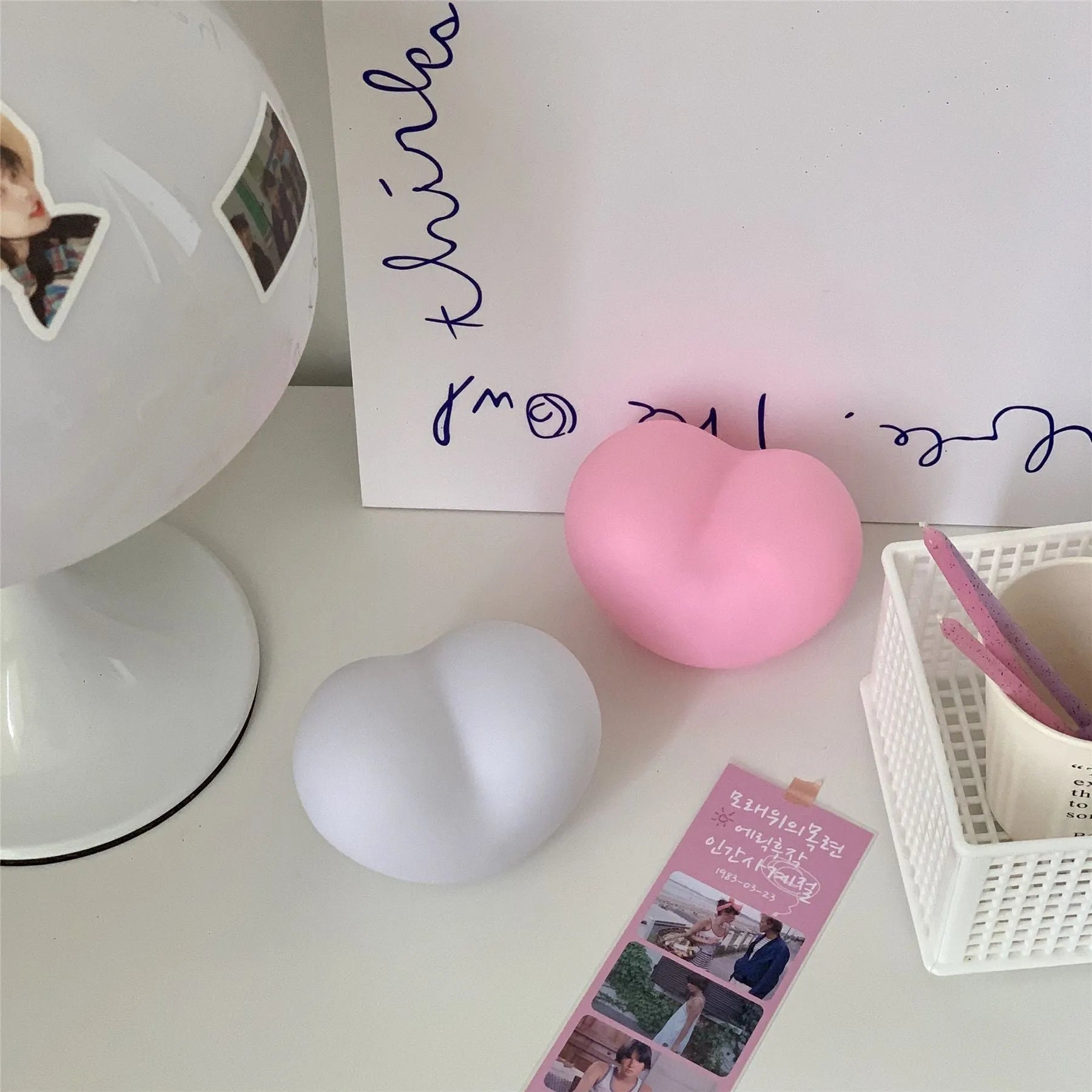 White or pink vinyl love heart atmosphere lamp in small or large size on a table.