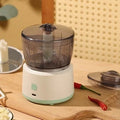 Mini meat grinder with white body, transparent 225ml cup, and anti-slip base on a kitchen countertop