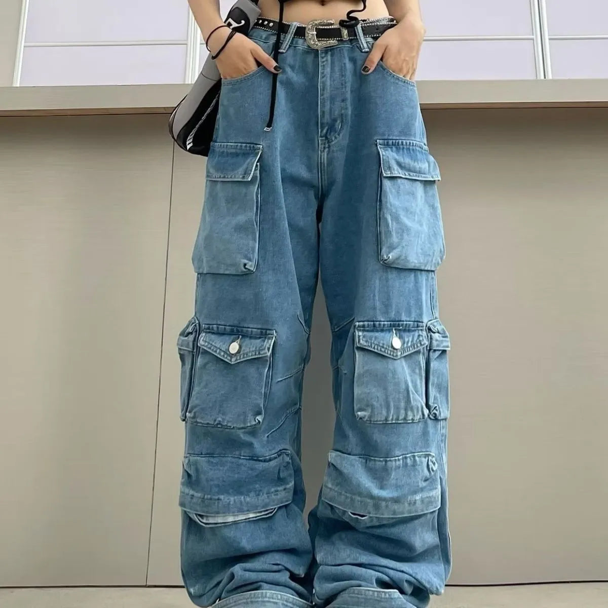 Women's blue tie-dyed wide-leg high-waist jeans with multiple pockets on a street hipster style denim overall.