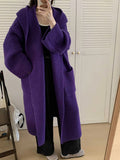 Women's loose grey hooded cardigan coat with raglan sleeves on a hanger