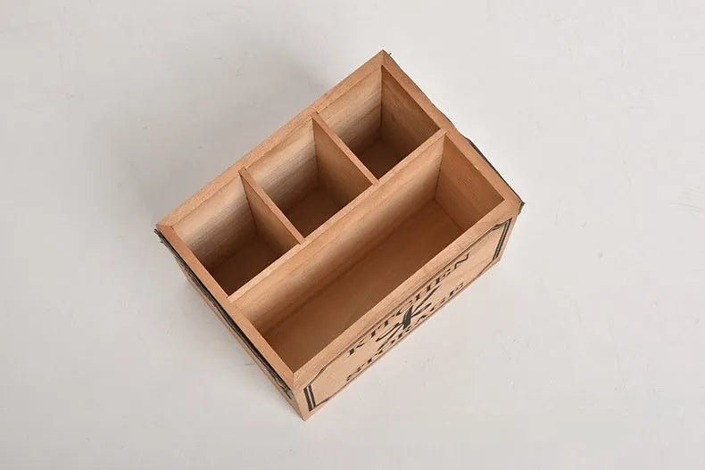 Open wooden kitchen storage box with internal grid holding knives, forks, and chopsticks.