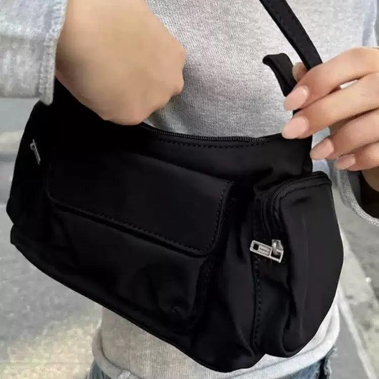 Black women's shoulder bag with double pockets and crossbody strap showing side line detailing