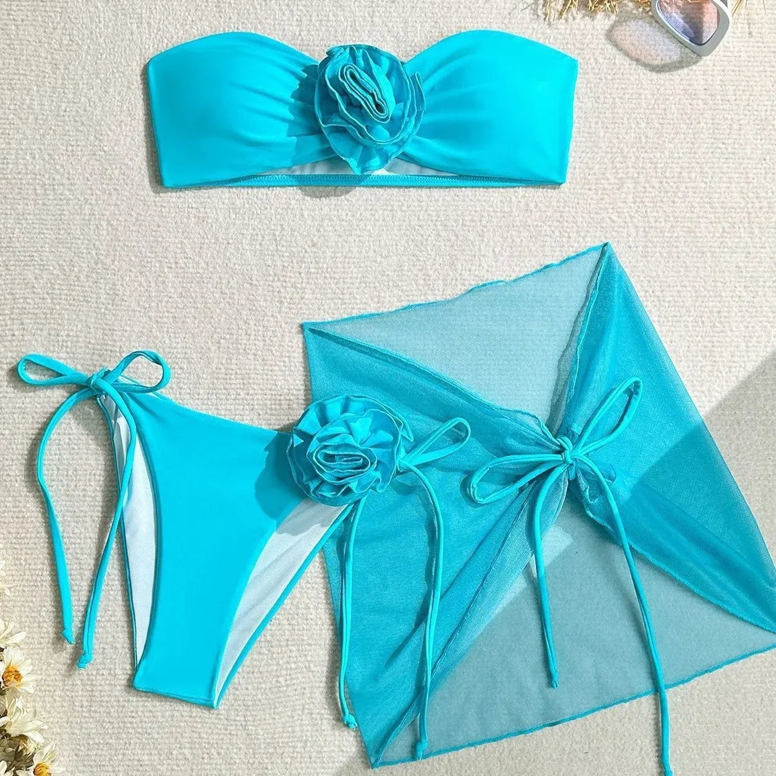 Women's pink tube top swimsuit with 3D flower tie, matching bottoms, and a skirt laid flat.