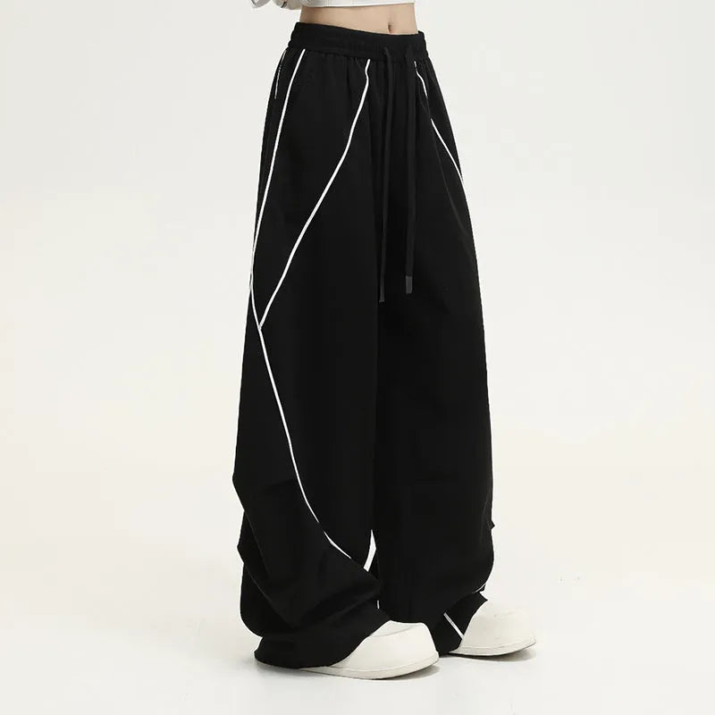 Black pleated wide-leg sports trousers with vertical stripe pattern and mid waist