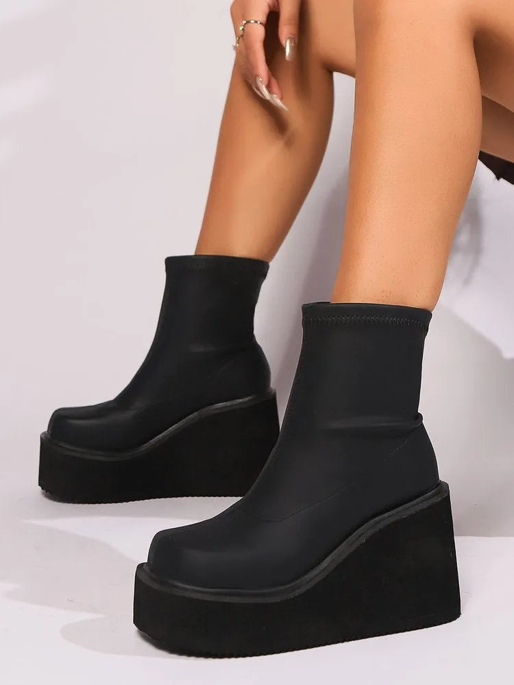 Black plus size women's wedge heel boots with a round toe and high cylinder shaft.