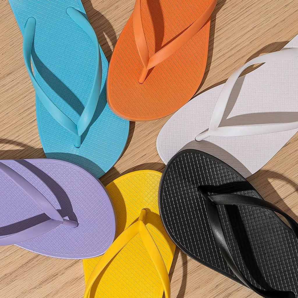Foldable plastic beach slippers with non-slip sole in black, shown open and folded.