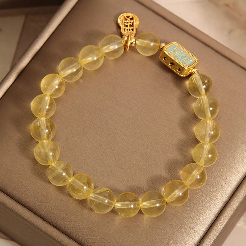 Women's natural yellow crystal bracelet with citrine colour round beads and rhinestone accents, sliding knot closure