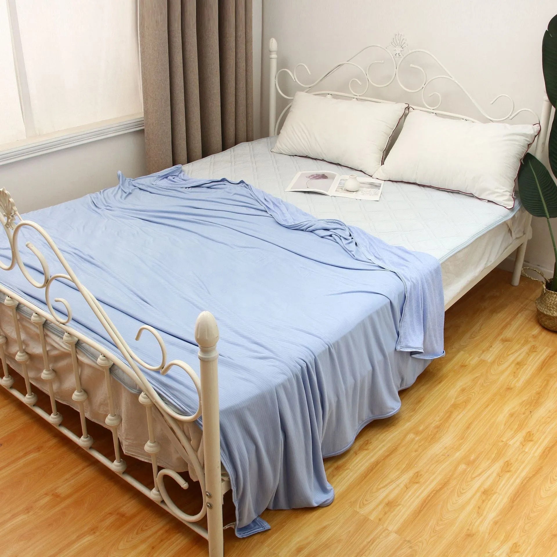 Blue cooling blanket with Q-Max 0.4 cooling fibers, polyester fabric, folded on a bed